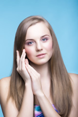 Fototapeta premium Beautiful young girl on the blue background