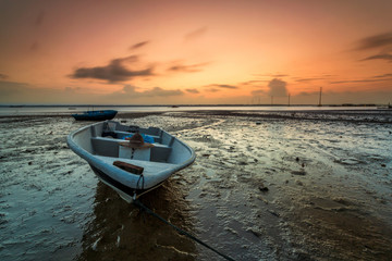 Long exposure picture of fishing boat with golden sunset as a background