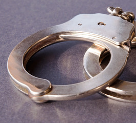 Metal handcuffs shown on a black background