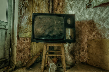Creepy broken television in dirty room of abandoned house