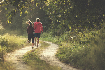 Obraz premium young couple jogging along a country road