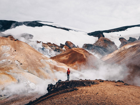 Person standing at rocks over hot springs