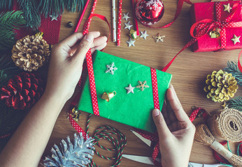 Merry christmas concepts with human hand decorating gift box present and ornament element.winter season's greetings