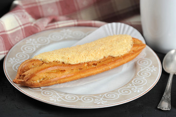 cake Eclair on a plate with a Cup of tea