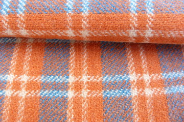 checkered wool fabric closeup drape orange white blue squares stripes geometric pattern background