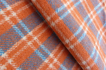 checkered wool fabric closeup drape orange white blue squares stripes geometric pattern background