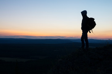 Man meets sunset on the top of the mountain.