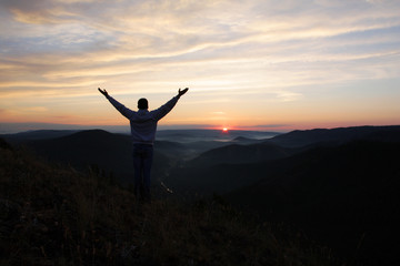 Man meets dawn on the top of the mountain.