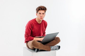 Teenager student with working at laptop and tablet on white background