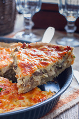 Quiche with chicken and mushrooms on a wooden table, selective focus