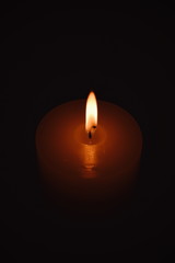 White burning candle on a dark background. Earth hour.