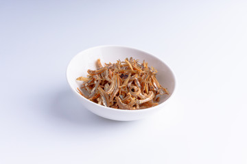 Fried anchovies on white background with selective focus and crop fragment