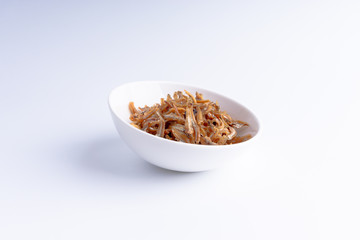 Fried anchovies on white background with selective focus and crop fragment