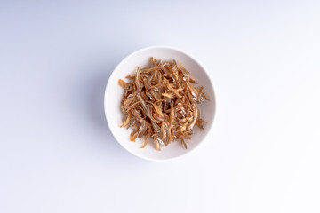 Fried anchovies on white background with selective focus and crop fragment