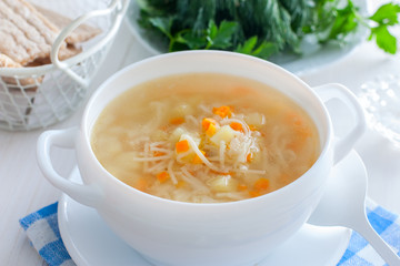 Chicken vermicelli soup and potatoes in a white bowl, horizontal