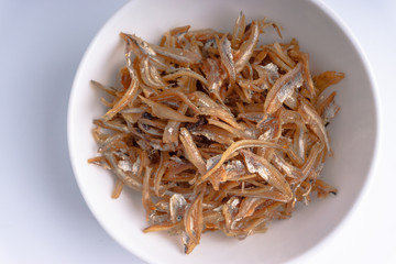 Fried anchovies on white background with selective focus and crop fragment