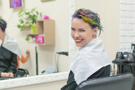 A woman is done coloring her head in blue at the hairdresser’s salon. Change the image of a woman.