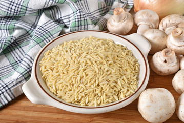 Uncooked orzo pasta with mushrooms and onions