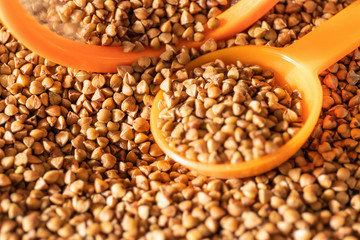 Buckwheat, jar fragment and spoon close-up. The concept of dietary nutrition. Selective focus shallow depth of field
