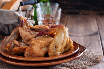Baked chicken wings on a wooden table, horizontal, copy space