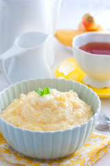 Milk corn porridge in a blue bowl for breakfast, selective focus