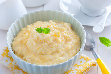 Milk corn porridge in a blue bowl, horizontal