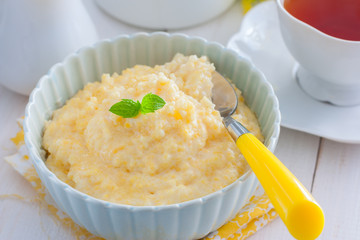 Milk corn porridge in a blue bowl, horizontal