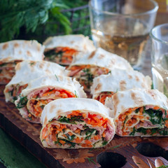 Lavash snack with Korean carrots on a wooden board, square
