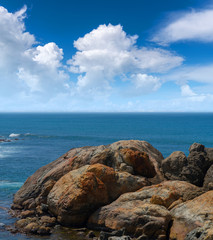 Fototapeta na wymiar Large rocks in ocean near shore.