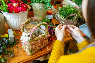 Female hands making beautiful bouquet of flowers on background