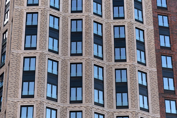 Fototapeta premium Colorful Brick wall of a skyscraper with windows.