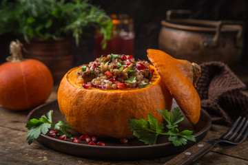whole pumpkin stuffed with barley and vegetables, served with pomegranate and parsley