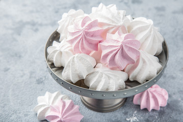 white and pink meringues on cake stand,
