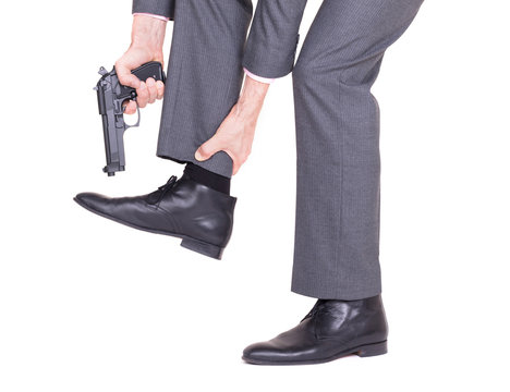 Businessman shooting himself in the foot with a handgun