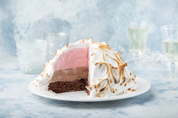 Baked Alaska, chocolate and strawberry ice cream cake with meringues