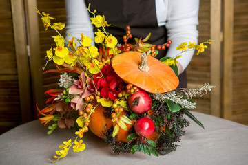 Florist at work: How to make a Thanksgiving centerpiece with big pumpkin and bouquet of flowers. Step by step, tutorial.