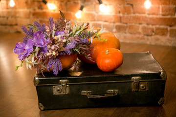 Bright autumn bouquet in a pumpkin on dark background