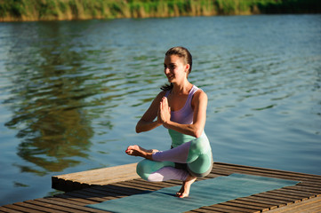 Young healthy woman practicing yoga at sunset