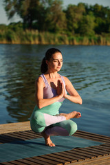 Fototapeta na wymiar Young healthy woman practicing yoga at sunset