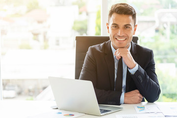 Portrait of young businessman working in office with smile. Manager or smart working people concept.