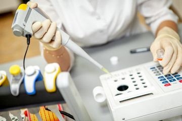 The laboratory assistant places a blood sample for analysis in a special apparatus, close-up