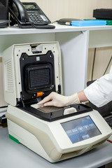 The specialist of the laboratory places the samples in a special apparatus for studying the composition