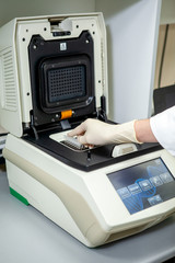The specialist of the laboratory places the samples in a special apparatus for studying the composition