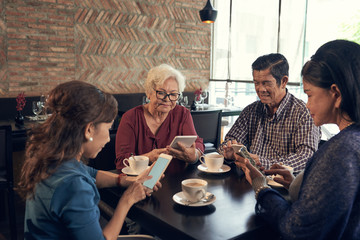 Senior peope using gadgets instead of talking with each other