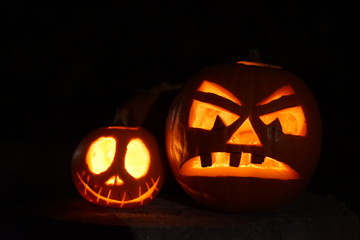 Carved scary halloween pumpkins jack-o-lantern on black background with candles inside