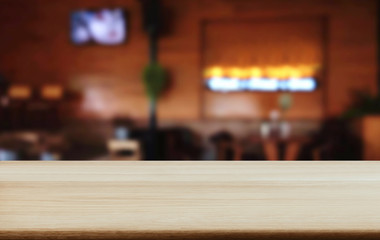 Empty wooden table and blurred background of abstract in front of coffee shop or restaurant for display of product or for montage
