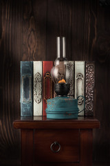 Still life with a vintage kerosene oil lamp and old vintage books