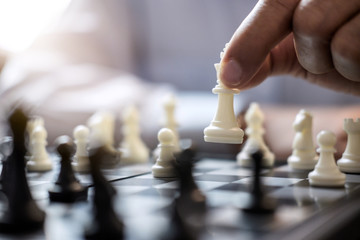 Businessman's hand playing chess game to development analysis new strategy plan, business strategy leader and teamwork concept for win and success
