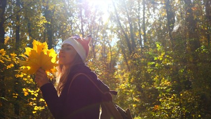 Girl in the autumn forest spends carefree time