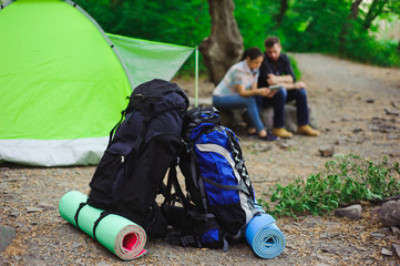 the tent, two backpacks near a tourist track in mountains